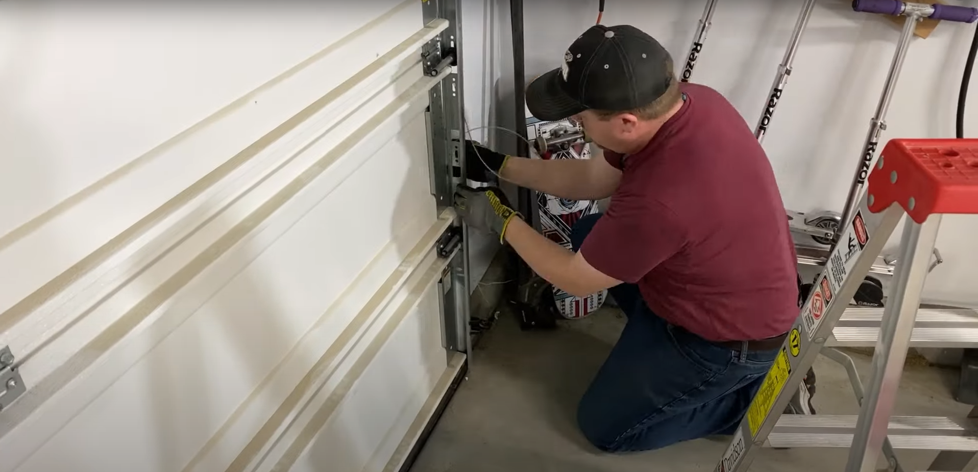 A professional technician repairing a residential garage door.