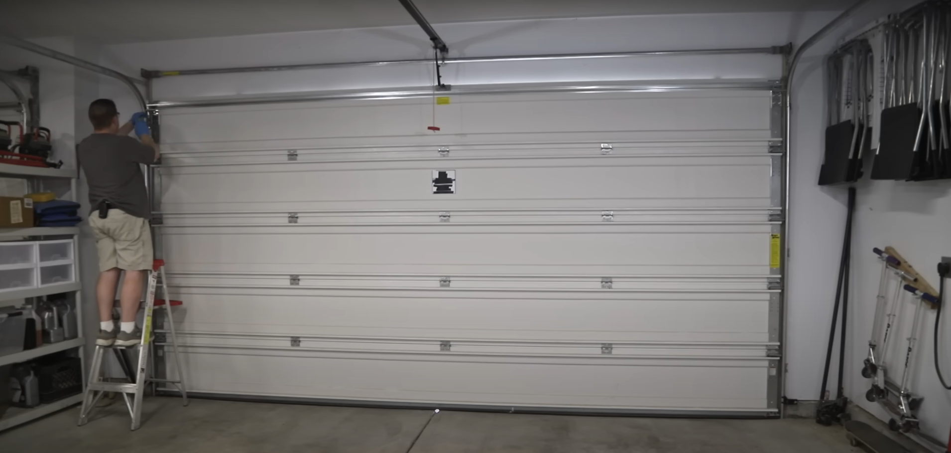 A professional technician repairing a residential garage door.